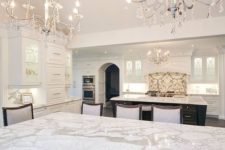 22 two chic chandleiers with some hanging crystals, marble and lots of white makes the kitchen exquisite