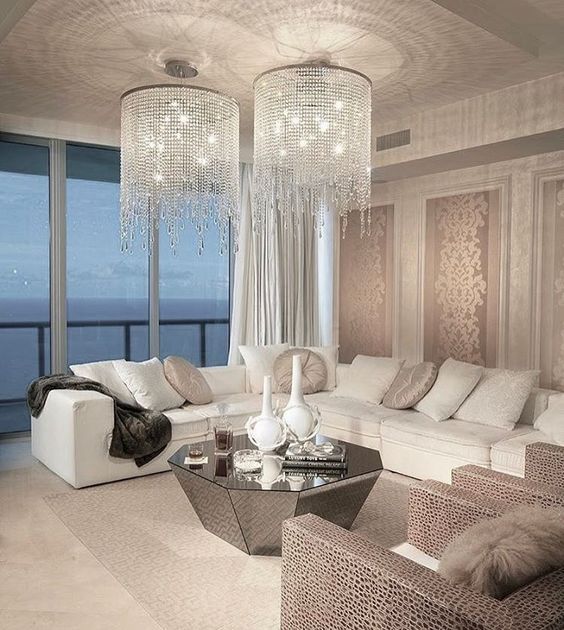 a modern living space with a corner sofa and long crystal chandliers with cascading crystals