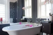 23 a white tub on black claw feet for a modern feminine bathroom