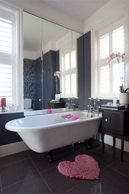 a white tub on black claw feet for a modern feminine bathroom