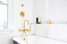 23 brass fixtures, a black tub and a marble wall to shine