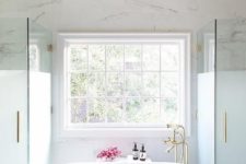 25 chic master bathroom boasts oval freestanding tub and a brass vintage tub filler placed under a window