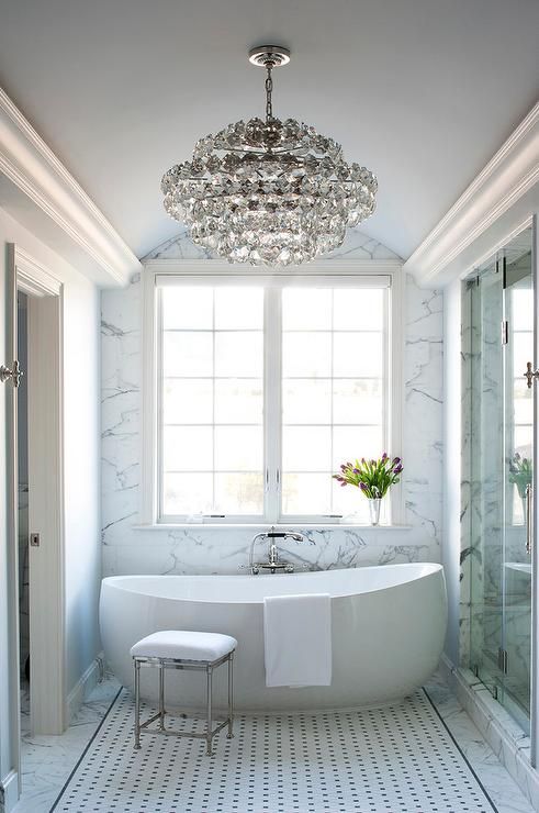 an oversized crystal chandelier in a modern bathroom makes it chic and more girlish
