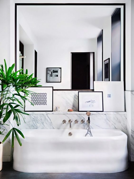 modern fresh bathroom with a large tub, an oversized mirror and a shelf