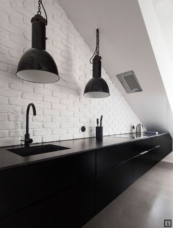 oversized industrial black pendant lamps in a black and white kitchen