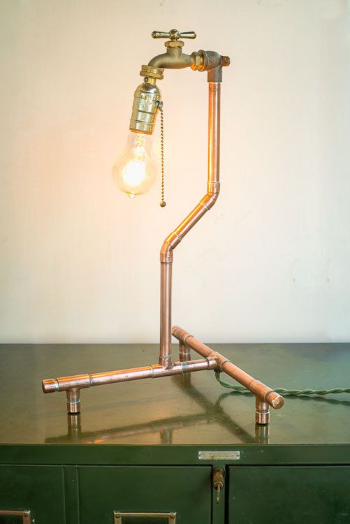 a copper fixture lamp with a bulb and a faucet