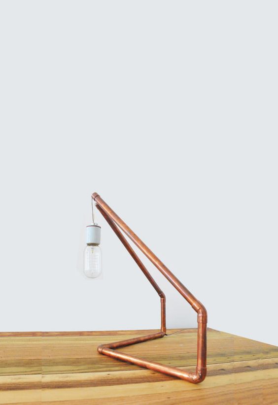 a simple copper pipe geometric lamp with a bulb