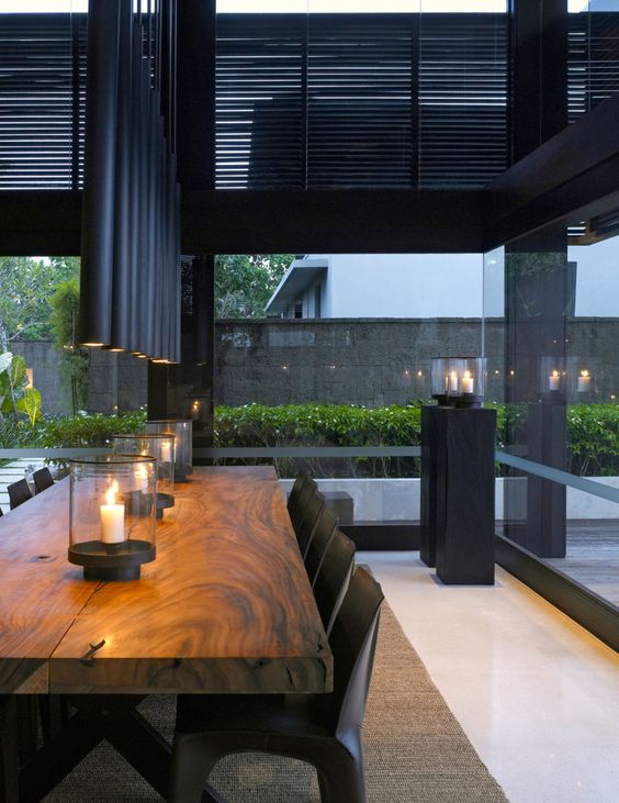Tube like matte black pendants make the dining space manly