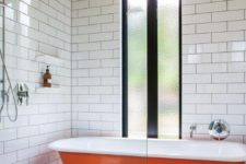 31 a bold orange bathtub in the shower zone with subway tiles