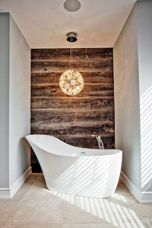 a niche with a reclaimed wall, a glam pendant lamp and a shoes-shaped tub