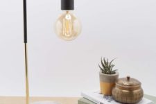 32 an industrial lamp with a marble base, a brass touch and black elements and a bulb