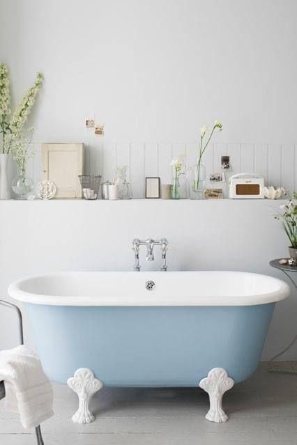 a neutral bathroom with a built-in shelf is complemented with a powder blue clawfoot tub