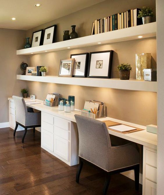 floating shelves with lights underneath and two desks for a shared home office