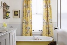 38 a sunny yellow bathtub and floral curtains for a shiny bathroom