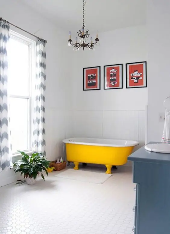 modern bathroom with blue touches and a sunny yellow bathtub with legs