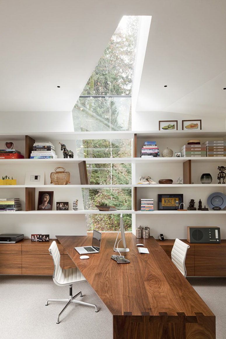 This modern house is strongly connected to the outdoors with glazings, cutouts and skylights