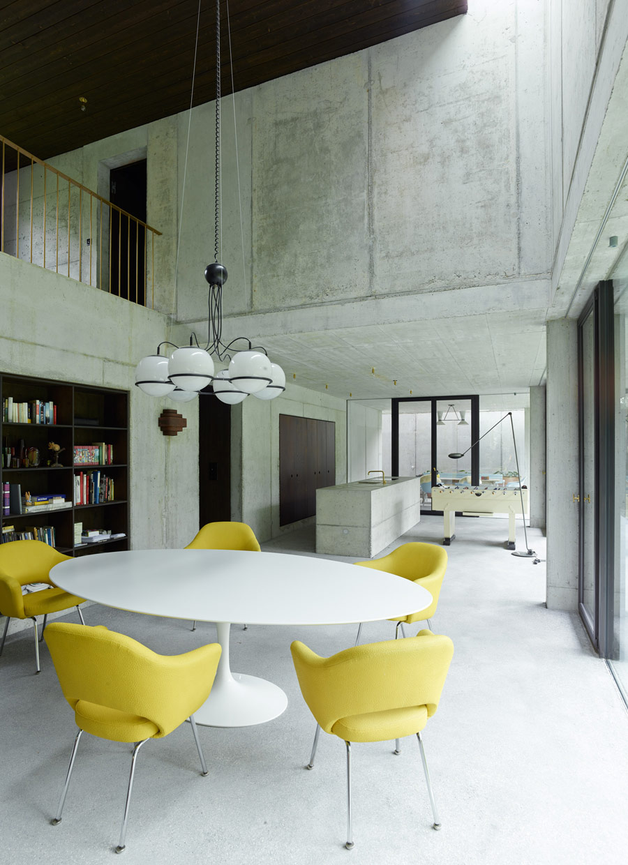 The dining space is modern and vibrant, with sunny yellow chairs and built-in bookshelves