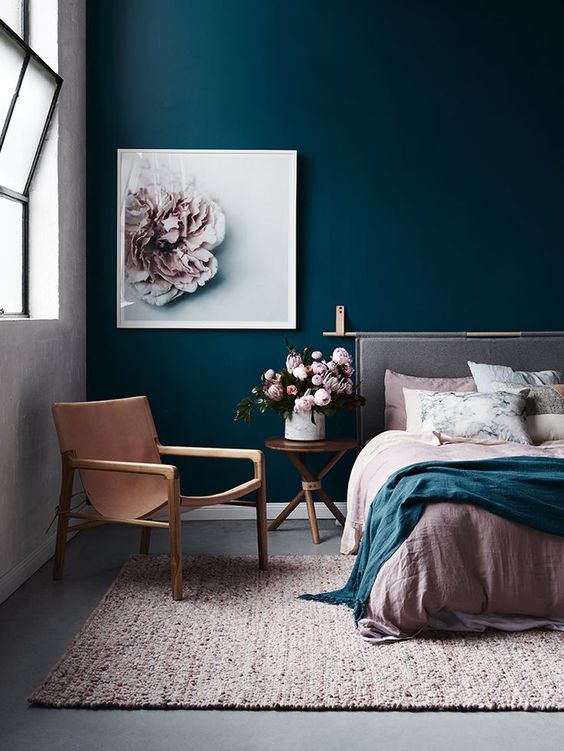 a combo of a navy statement wall and blush textiles and a blush flower artwork looks very refined