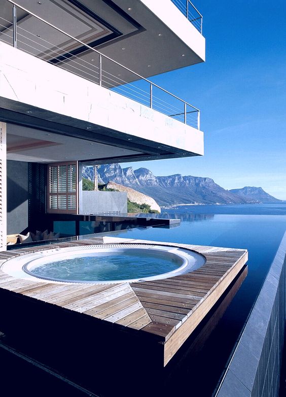 a floating wooden deck in the water with a jacuzzi, a stunning view