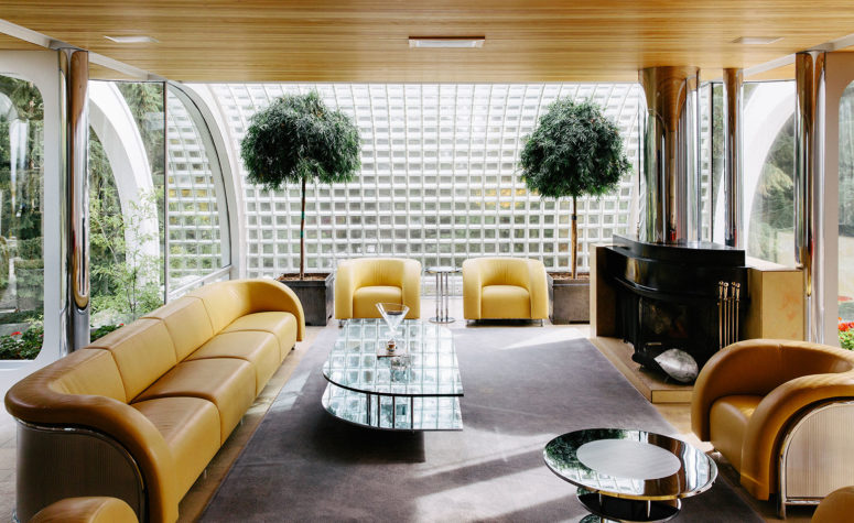 The curved lines of the living area's seating, coffee table and fireplace mimic the form of the house