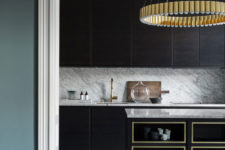 03 The kitchen is very refined, with dark stained cabinets, brass chandeliers and gilded frame kitchen island