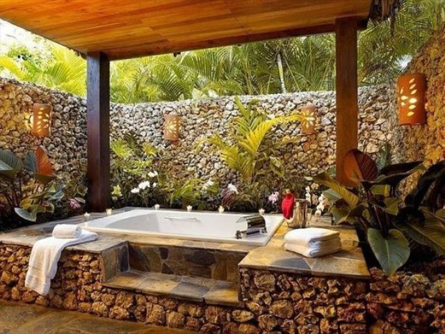 a jacuzzi covered with stone and with a stone wall all around to keep the space private