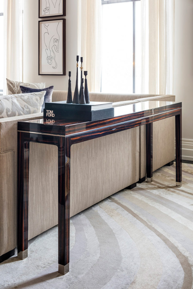 The console table is of dark stained and polished wood, and it adds elegance