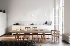 04 The kitchen and dining space are united in one, with white cabinets and light-colored wooden dining set