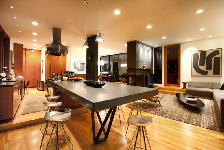 The kitchen features a large concrete kitchen island and a breakfast table at the same time