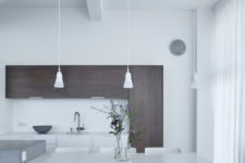 04 The kitchen features dark stained wooden cabinets with no handles and white ones for a contrast