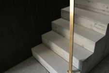 05 The staircase is concrete. with minimalist brass rails