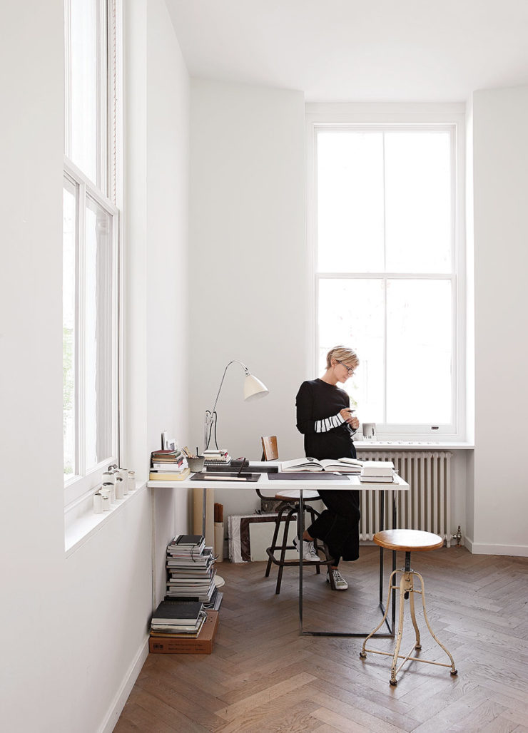 This is the workspace of the designer, with a wall-mounted desk and vintage stools