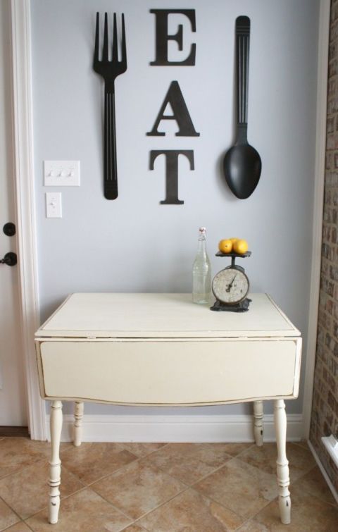 EAT letters and oversized black utensils to decorate a wall