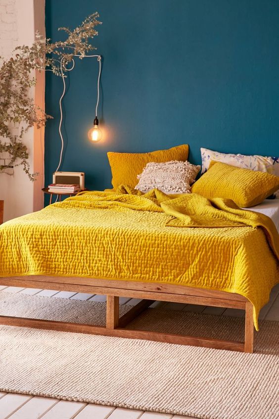 a navy statement wall contrasts with sunny yellow bedding
