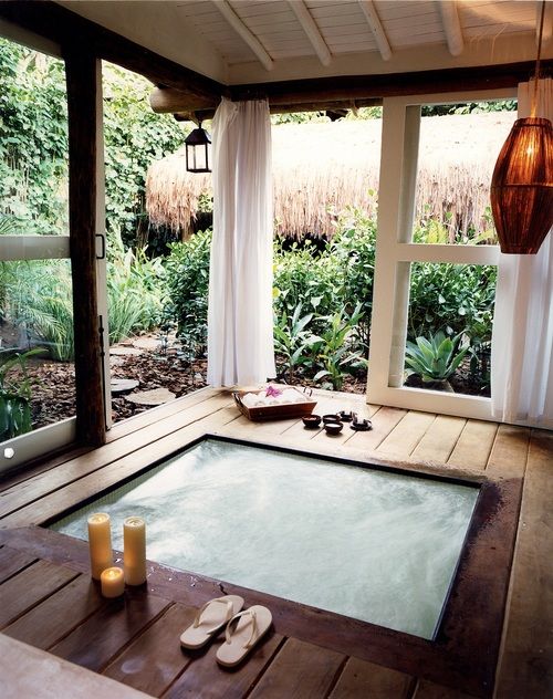 a sunken jacuzzi in a pavilion with glass doors for cases of bad weather