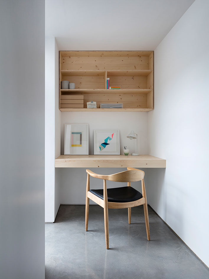 The workspace is with a built in desk and a cabinet over it, everything is simple and laconic
