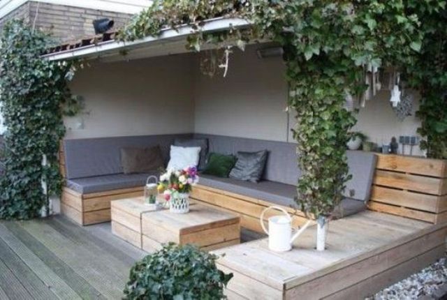 a deck with a large upholstered pallet bench and a matching pallet table