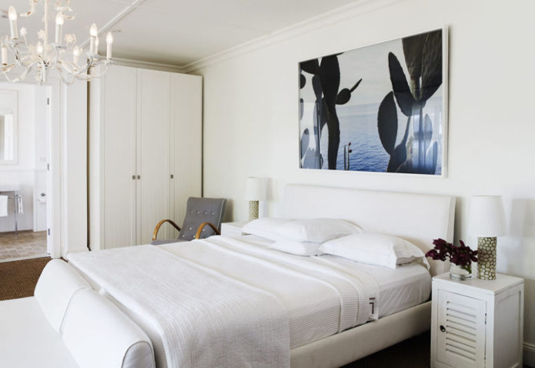 The first bedroom is decorated in creamy whites and neutrals, with a large photo artwork