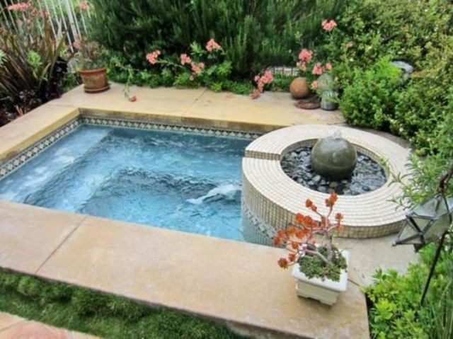garden jacuzzi clad with stone tiles with greenery around