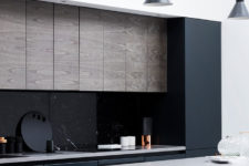 10 The kitchen is dark and masculine, with a cool texture combo of black marble, concrete and dark stained wood