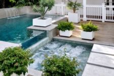 10 a jacuzzi next to the outdoor pool with a waterfall and a wooden deck