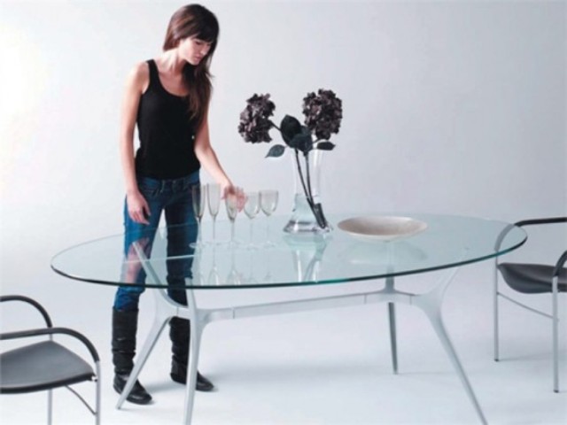 an oval glass top with unique spider-inspired legs that make it eye-catching