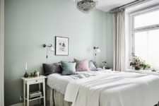 11 The master bedroom features green walls, a large crystal chandelier and soft textiles