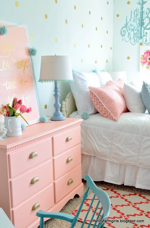 a salmon pink dress, pillows and an artwork are ideal for this cozy bedroom