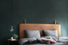 13 a brown leather upholstered bed with a dark green wall create a manly feel