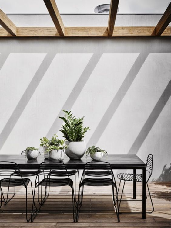 black dining table and black metal chairs for a chic modern terrace
