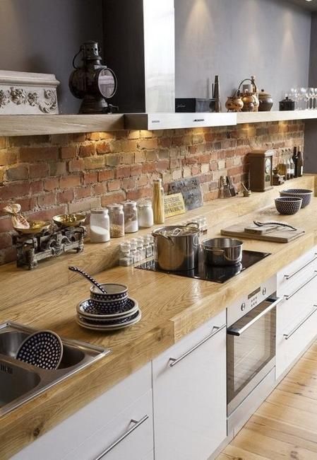 Polished light colored wooden counters enliven the kitchen decor