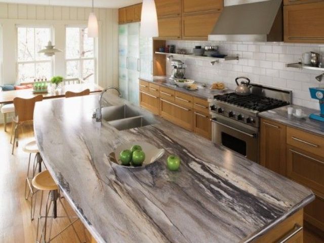 A chic granite counter contrasts with warm colored cabinets of wood