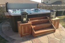 24 a jacuzzi with wooden stairs and lanterns on the corners