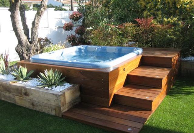 25 a jacuzzi with wooden steps and a wooden planter with succulents around
